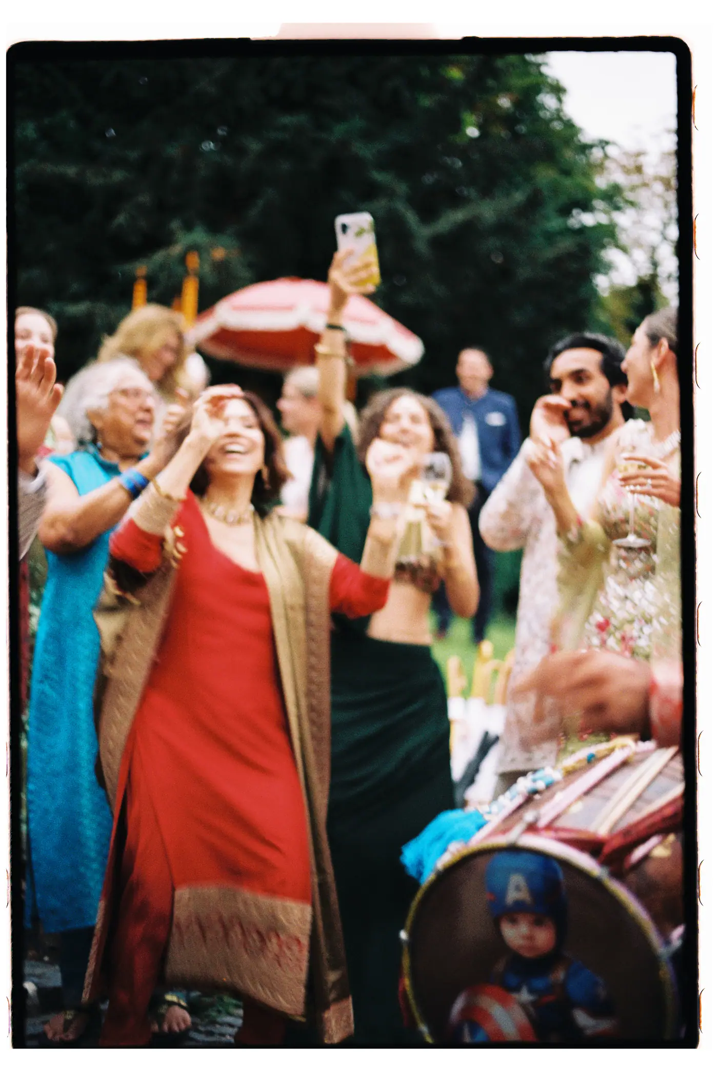 Guests dancing around a dhol drummer in the garden