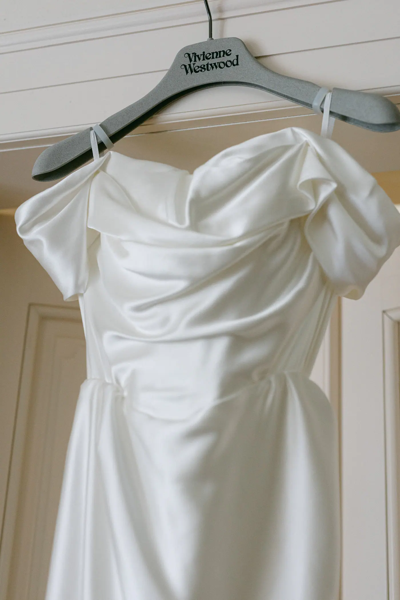 Satin wedding dress hanging on a Vivienne Westwood hanger