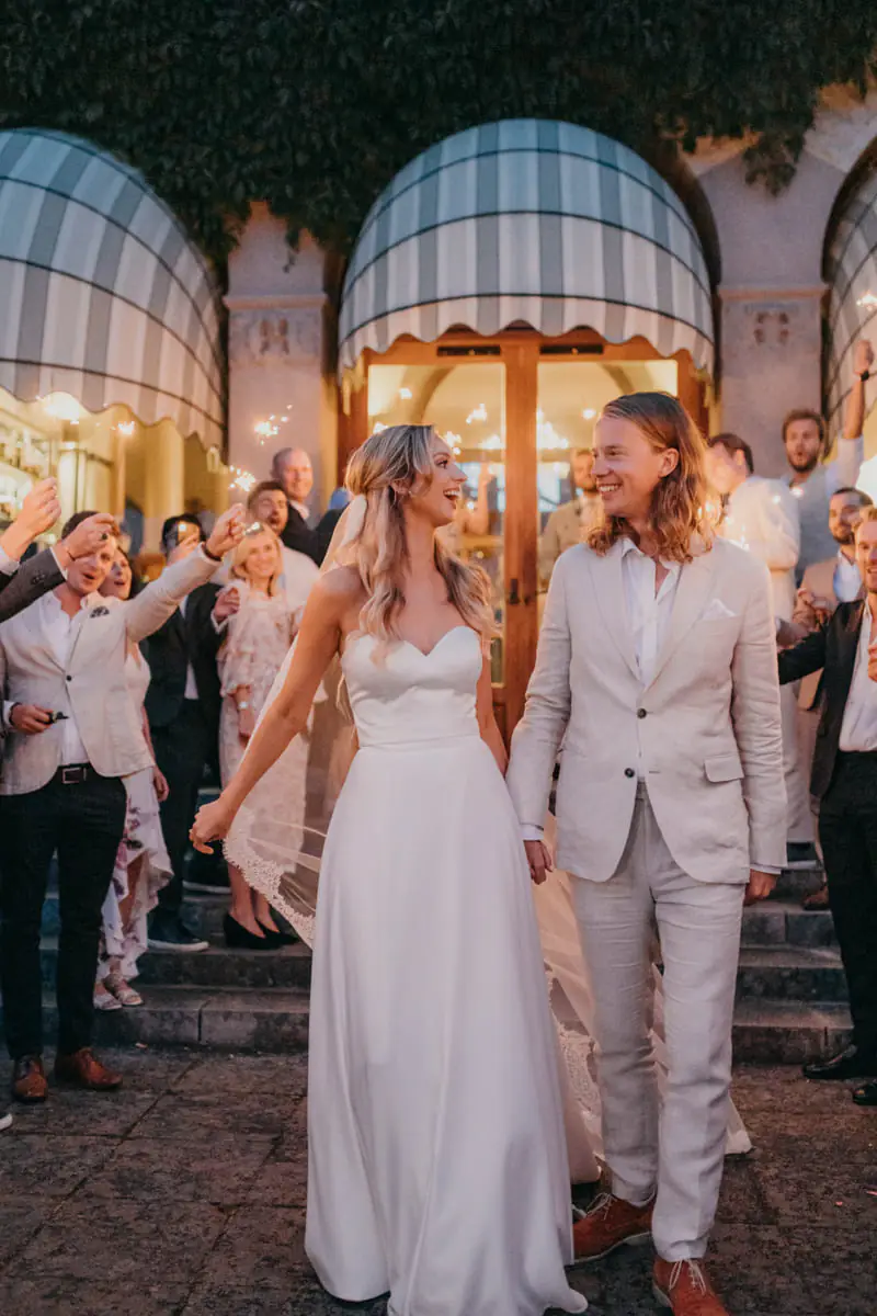 Bride and groom walking through cheering guests at an evening reception