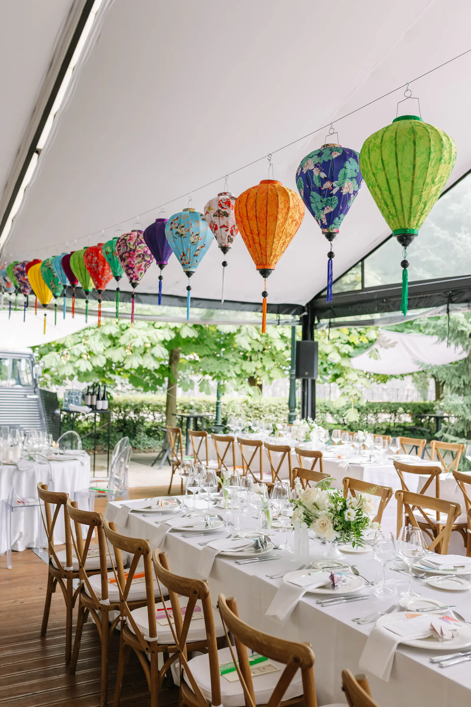 Long wedding reception table under colourful paper lanterns