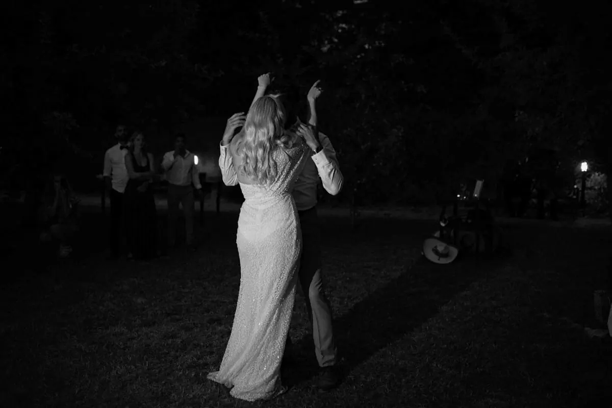 Black and white photo of a bride dancing at night