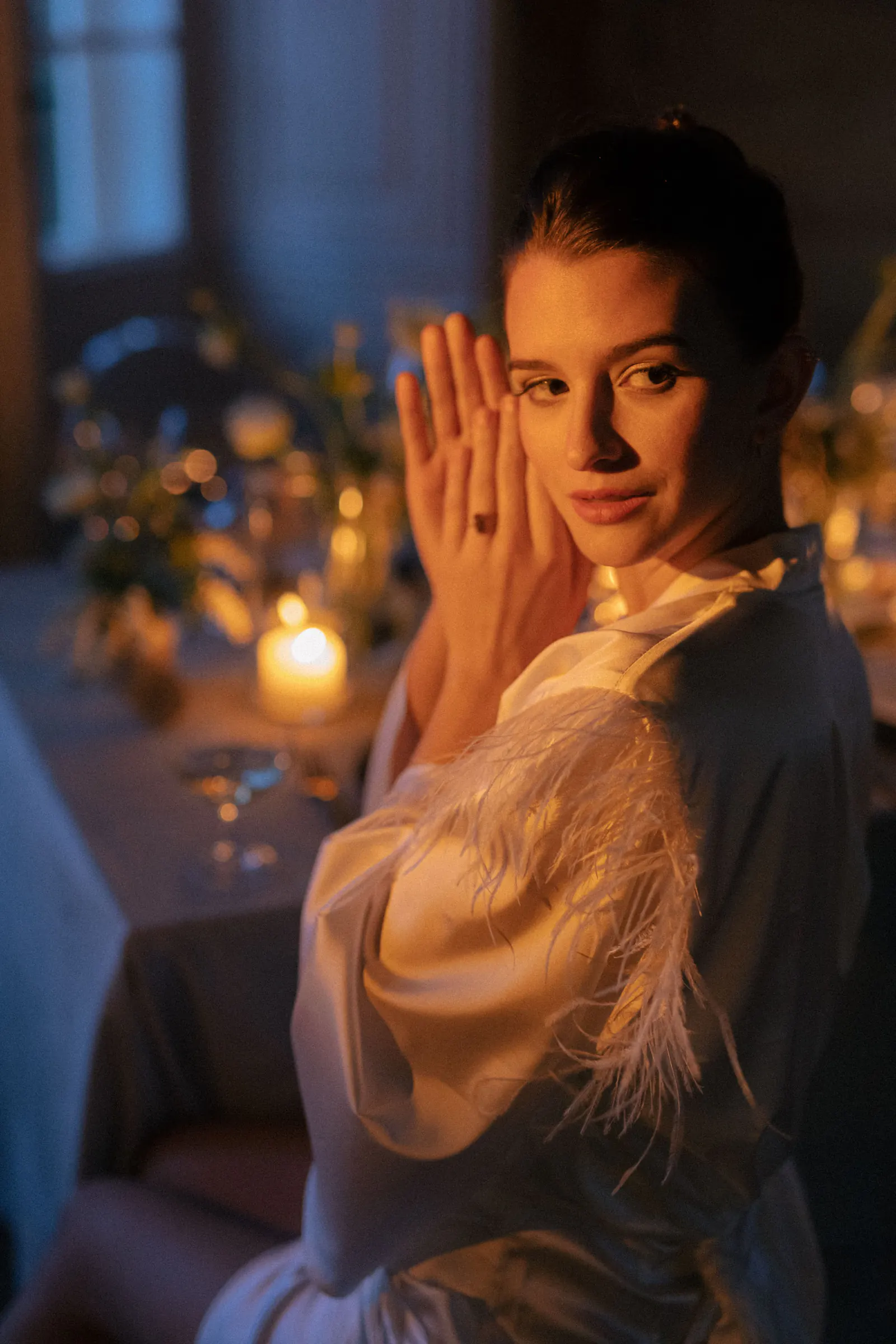 Bride in a feathered robe by candlelight