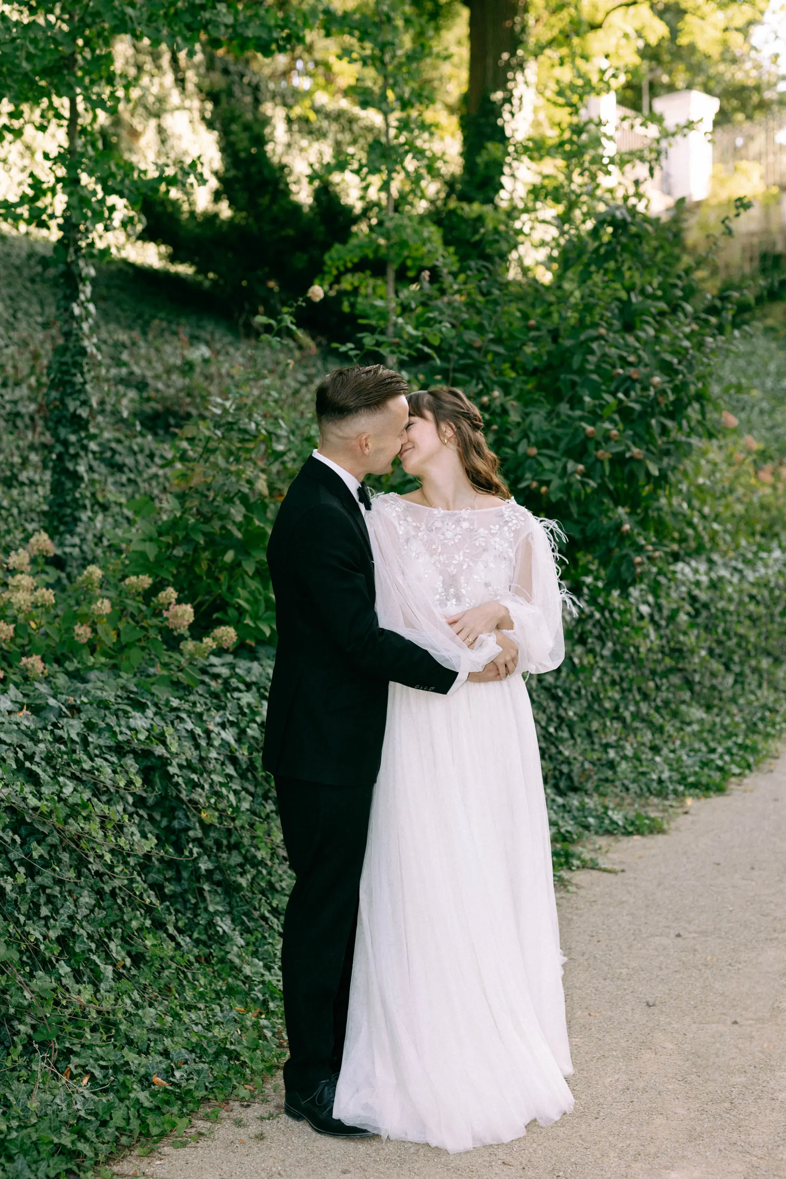 Bride and groom kissing in a green garden — Savoia Castle